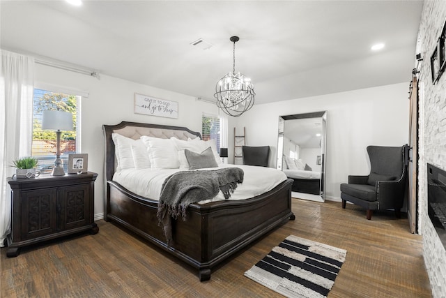 bedroom with dark hardwood / wood-style floors and an inviting chandelier