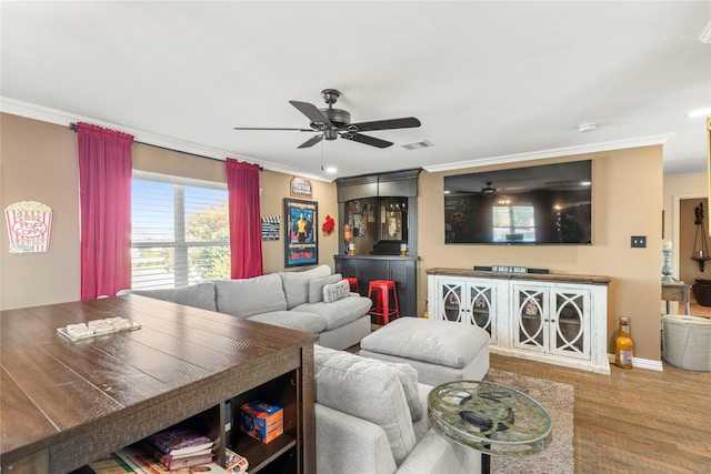 living room featuring hardwood / wood-style floors, crown molding, and ceiling fan