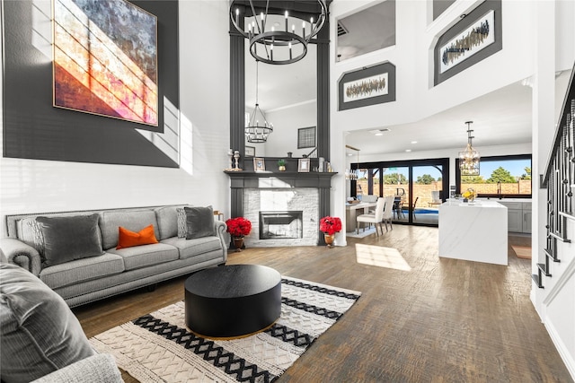 living room featuring a notable chandelier, a towering ceiling, and wood-type flooring