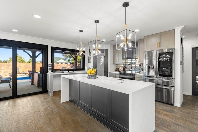 kitchen featuring appliances with stainless steel finishes, tasteful backsplash, ornamental molding, a kitchen island, and decorative light fixtures