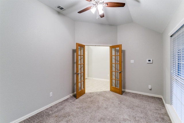 empty room with vaulted ceiling, light carpet, ceiling fan, and french doors