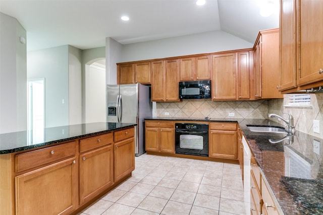 kitchen with sink, black appliances, and dark stone counters