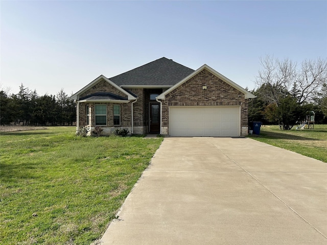 view of front facade with a front yard, driveway, a shingled roof, a garage, and brick siding