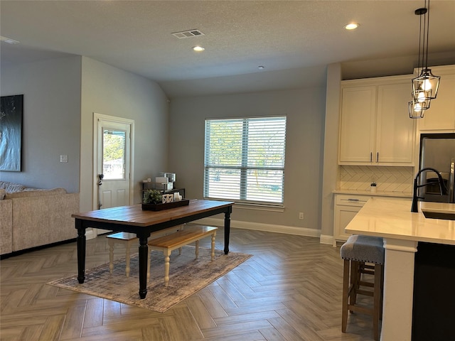 dining area with dark parquet floors and sink