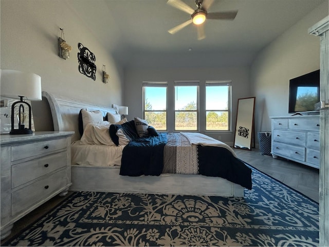 bedroom featuring ceiling fan, dark parquet flooring, and vaulted ceiling