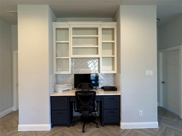 office space with baseboards and built in study area