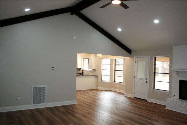 unfurnished living room featuring a fireplace, ceiling fan, dark wood-type flooring, and sink