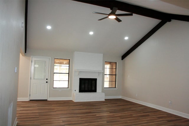 unfurnished living room with a brick fireplace, ceiling fan, dark wood-type flooring, high vaulted ceiling, and beamed ceiling