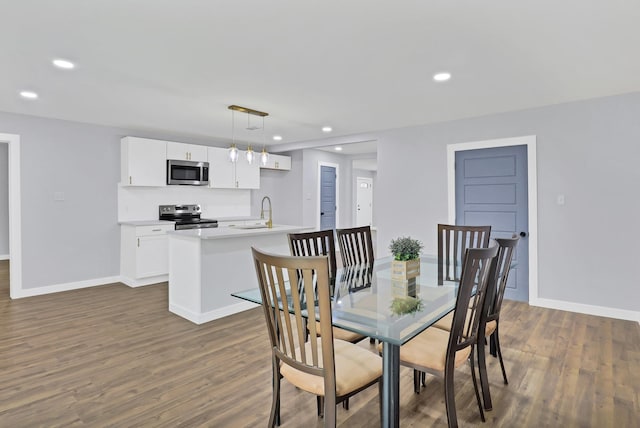 dining room with dark wood-style floors, recessed lighting, and baseboards