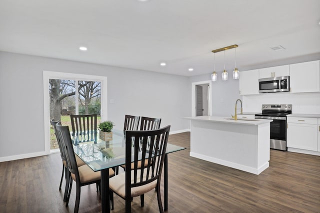 dining room with baseboards, dark wood-type flooring, and recessed lighting