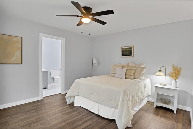 bedroom with connected bathroom, baseboards, and wood finished floors