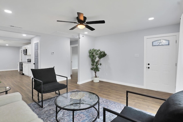 living room featuring dark wood-style floors, baseboards, visible vents, and recessed lighting