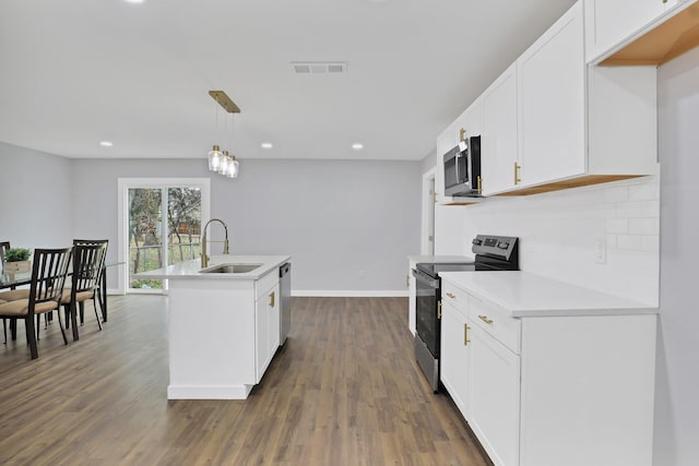 kitchen featuring a center island with sink, visible vents, stainless steel appliances, light countertops, and pendant lighting