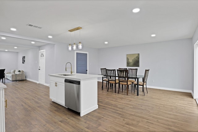 kitchen featuring visible vents, open floor plan, light countertops, stainless steel dishwasher, and pendant lighting