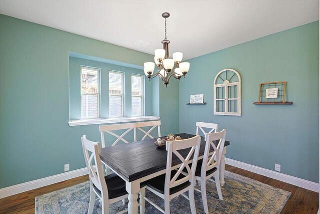 dining room featuring a notable chandelier and dark hardwood / wood-style floors