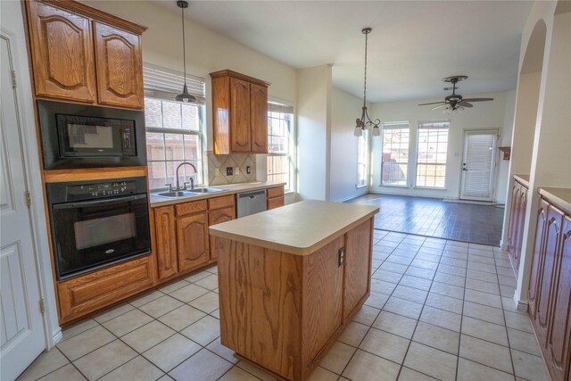 kitchen featuring light tile patterned floors, a kitchen island, hanging light fixtures, and black appliances