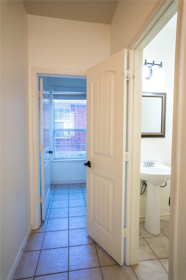 corridor with sink and light tile patterned floors