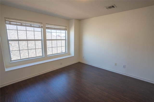 unfurnished room with dark wood-type flooring