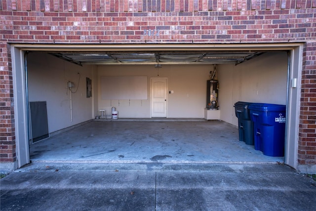 garage featuring electric panel and water heater