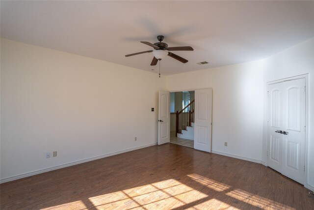 empty room with ceiling fan and dark wood-type flooring