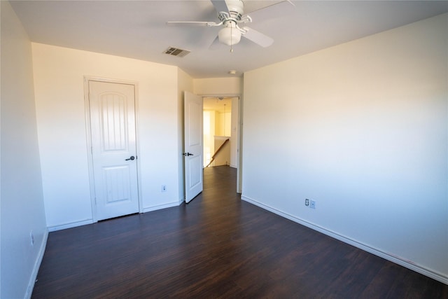 unfurnished bedroom with ceiling fan, a closet, and dark wood-type flooring