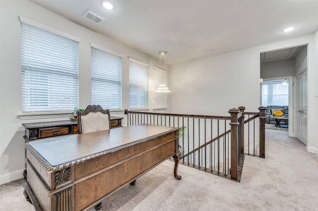 office space featuring plenty of natural light and light colored carpet