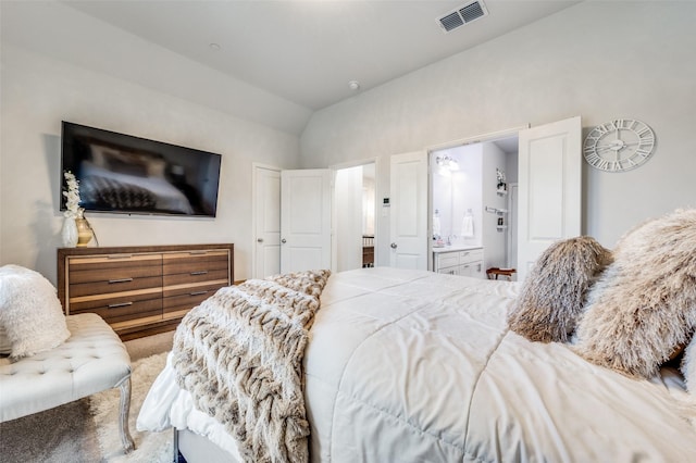 bedroom with carpet, vaulted ceiling, and ensuite bath