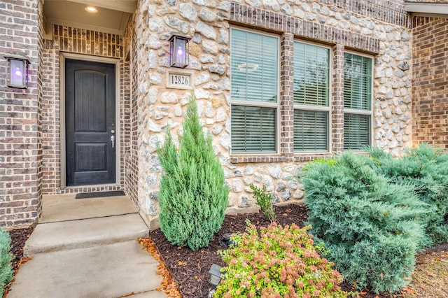 property entrance featuring stone siding and brick siding