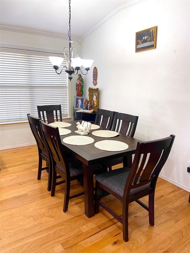 dining area with an inviting chandelier, light hardwood / wood-style flooring, and ornamental molding