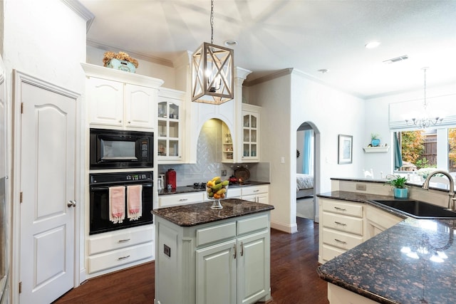 kitchen featuring sink, pendant lighting, a center island, and black appliances