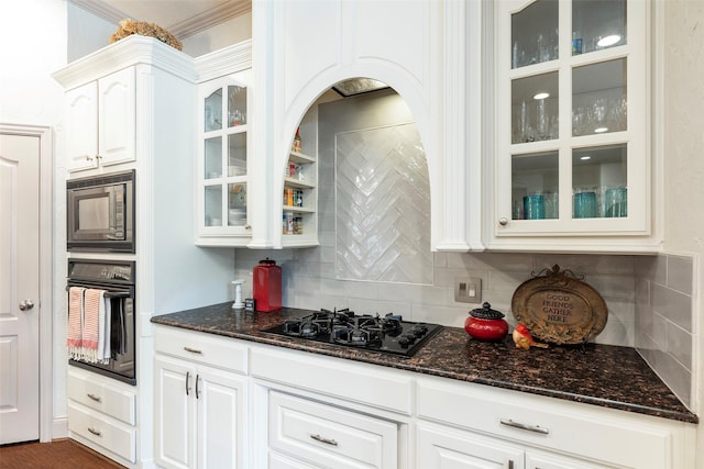 kitchen with tasteful backsplash, dark stone counters, crown molding, black appliances, and white cabinetry