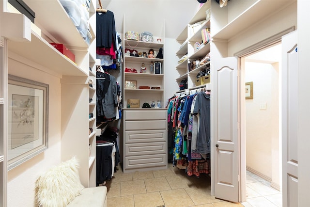 walk in closet with light tile patterned floors