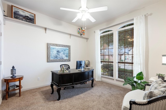 carpeted home office featuring ceiling fan