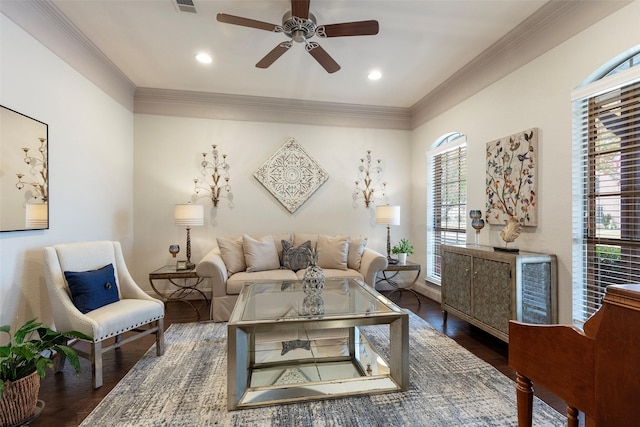 living room featuring ceiling fan, ornamental molding, and dark wood-type flooring