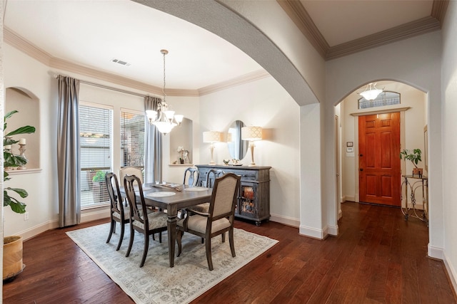 dining room with crown molding, dark hardwood / wood-style flooring, and a notable chandelier