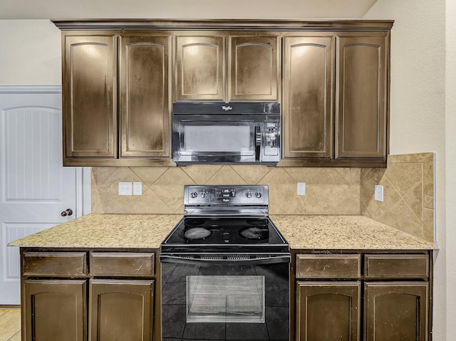 kitchen with black appliances, dark brown cabinets, light stone counters, and tasteful backsplash