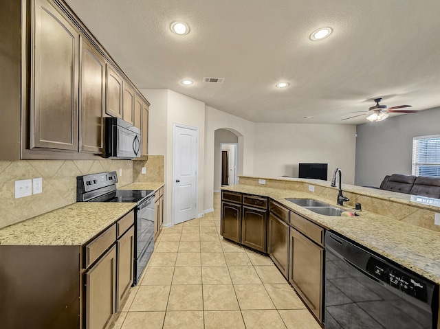 kitchen featuring open floor plan, black appliances, a sink, and visible vents