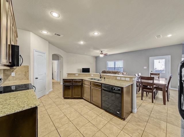 kitchen with light tile patterned floors, arched walkways, a sink, black dishwasher, and open floor plan