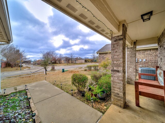 view of front facade with a front yard, central AC unit, and a garage