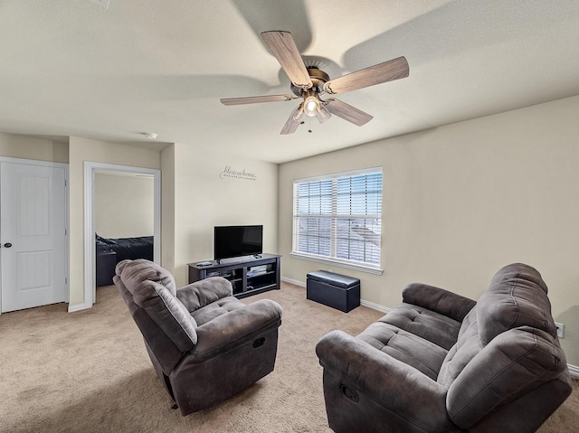 living room featuring ceiling fan, carpet, and baseboards