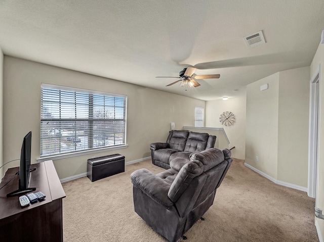 living room with light carpet, visible vents, baseboards, and a textured ceiling