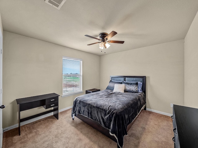 carpeted bedroom featuring ceiling fan, visible vents, and baseboards