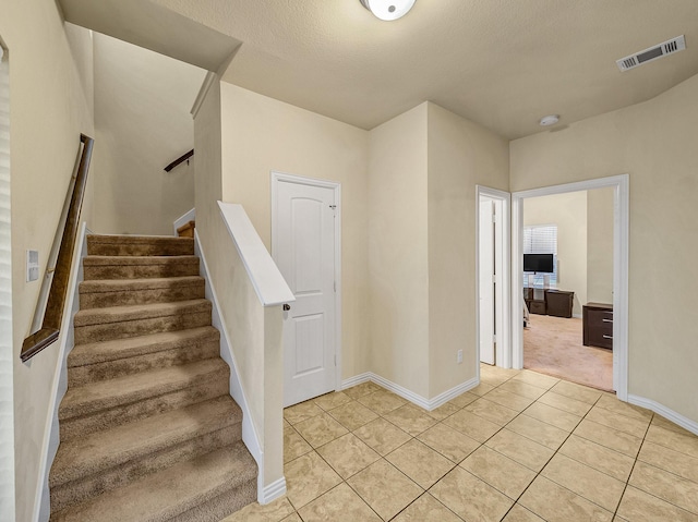 staircase featuring tile patterned flooring