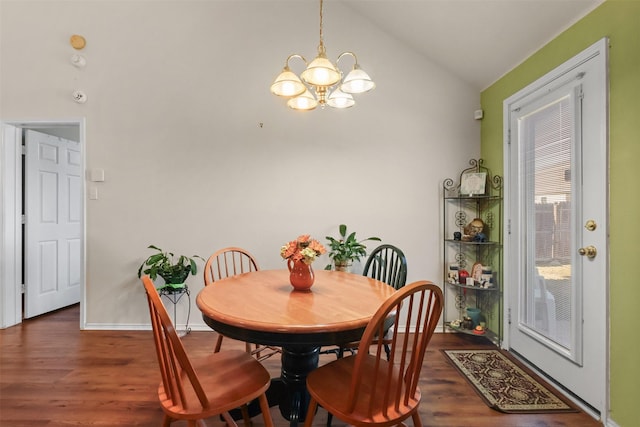 dining area with dark wood-type flooring, a chandelier, and vaulted ceiling