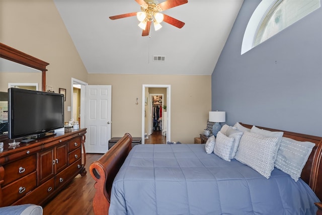 bedroom featuring dark hardwood / wood-style flooring, a spacious closet, lofted ceiling, and ceiling fan