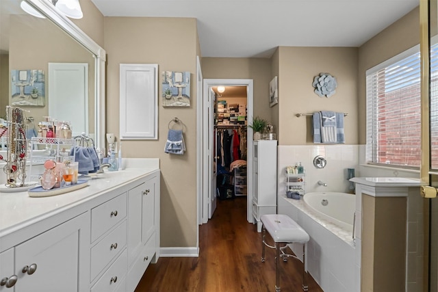 bathroom with vanity, hardwood / wood-style floors, and a tub to relax in