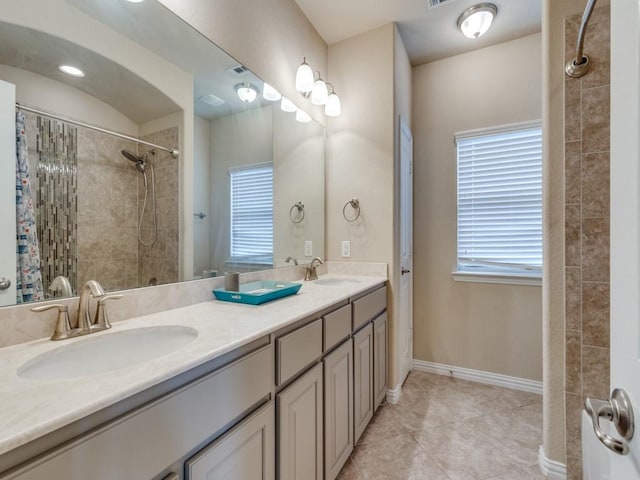 bathroom featuring a tile shower, vanity, and tile patterned floors