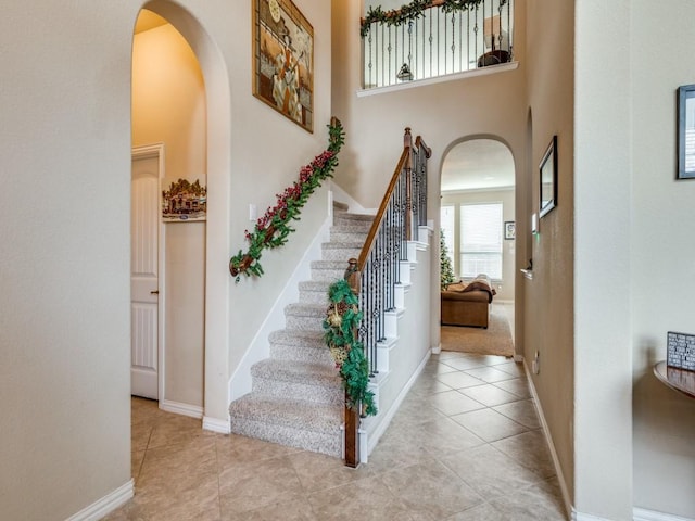 tiled entrance foyer featuring a towering ceiling