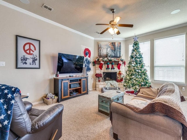 living room with carpet flooring, a stone fireplace, ceiling fan, and ornamental molding