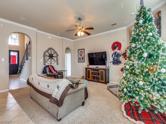 tiled living room with ceiling fan and crown molding